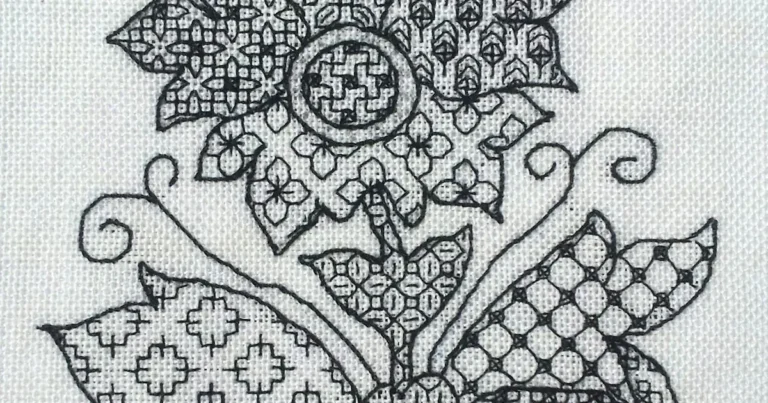 Blackwork embroidery with black geometric fill patterns stitched on white evenweave fabric