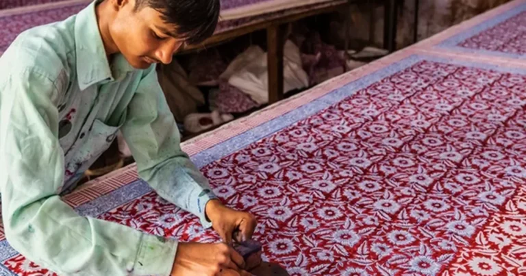 Hand-carved wooden block printing a pattern onto fabric