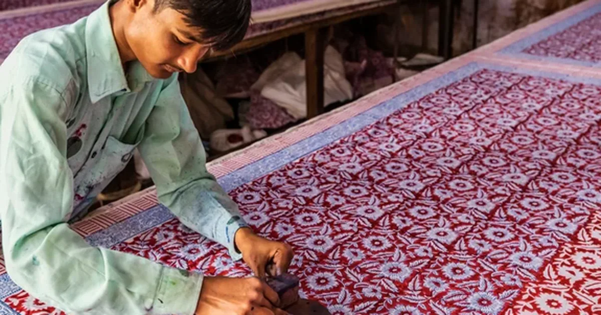 Hand-carved wooden block printing a pattern onto fabric
