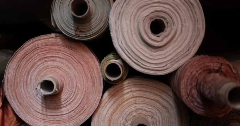 Close-up of colorful natural fabric rolls showing cotton linen and silk textures