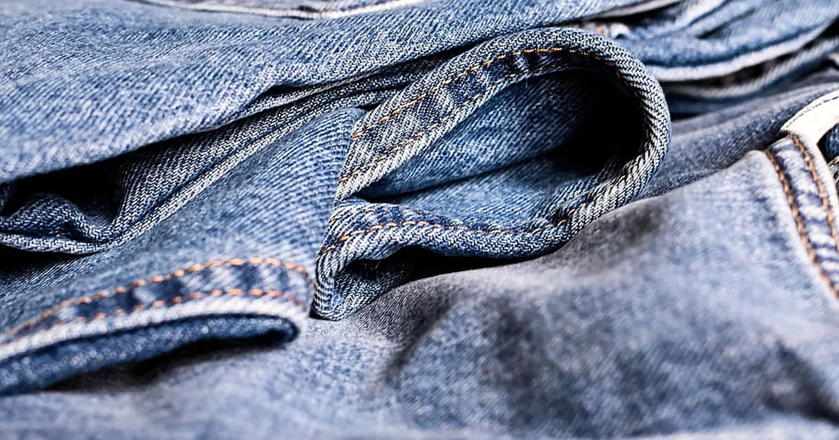 Close-up of blue denim jeans showing the twill weave and stitching