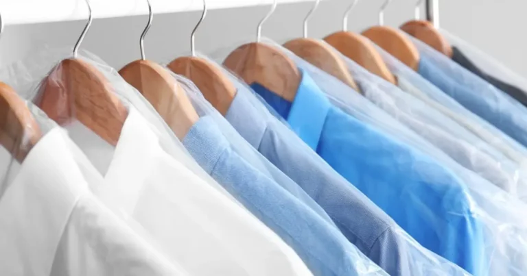 Freshly dry-cleaned garments hanging on a rack in protective covers