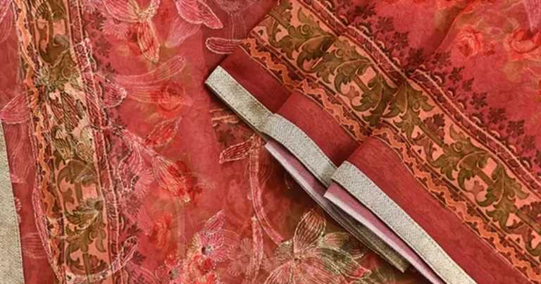Close-up of a coral pink embroidered dupatta with floral threadwork and a gold zari border
