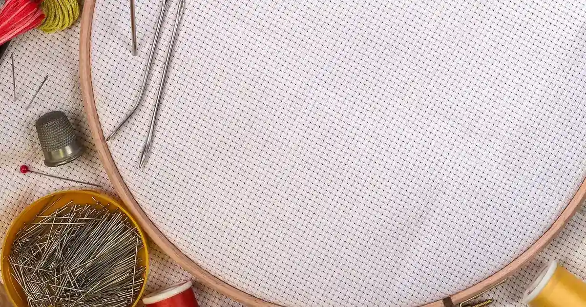 Embroidery hoops, needles and stitching tools on a worktable