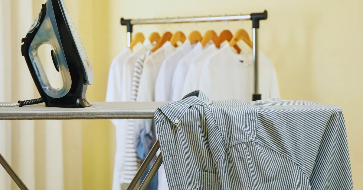 Steam iron pressing a garment on an ironing board
